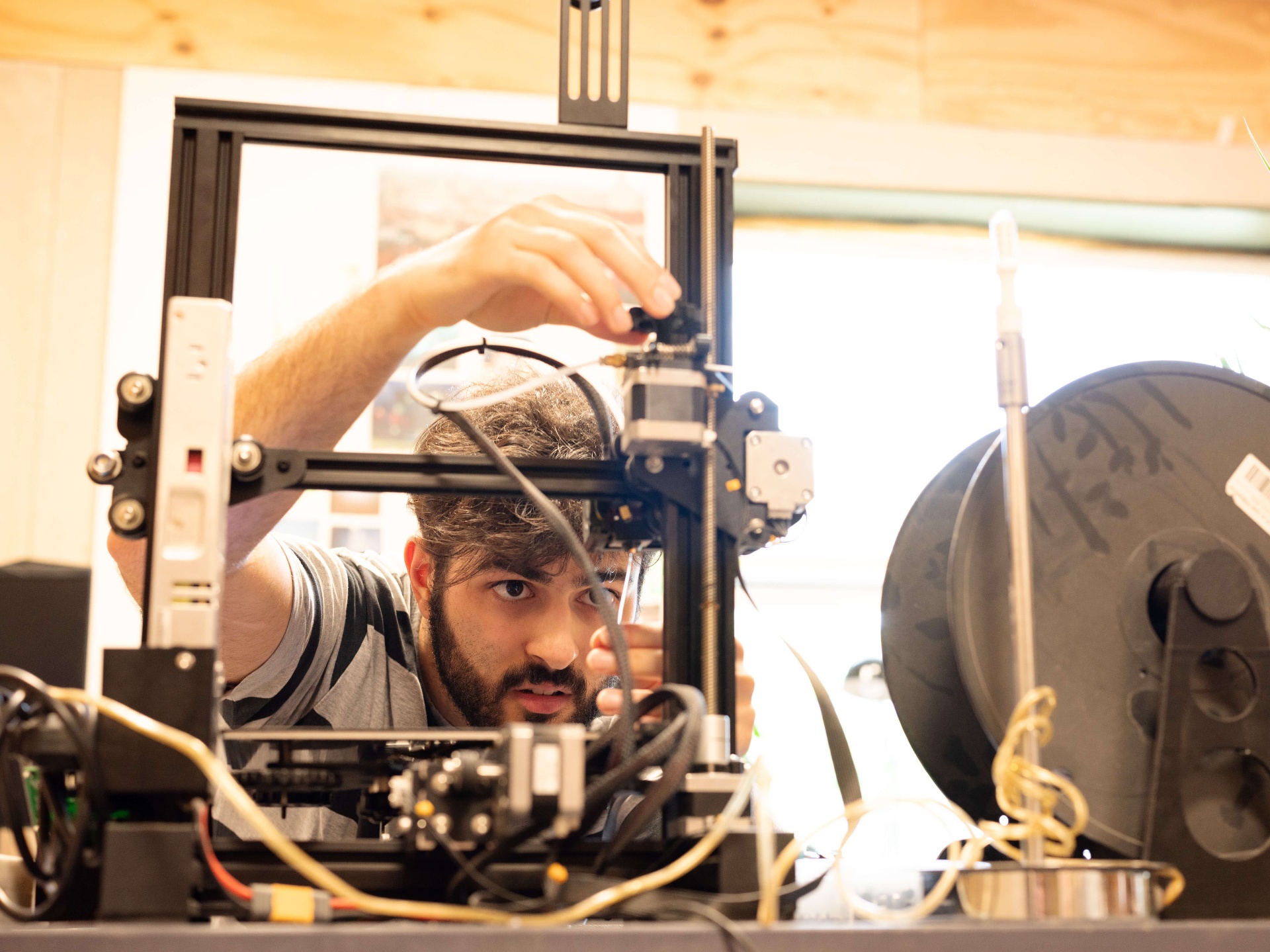 Søren Saket justerer en 3D-printer på værkstedet